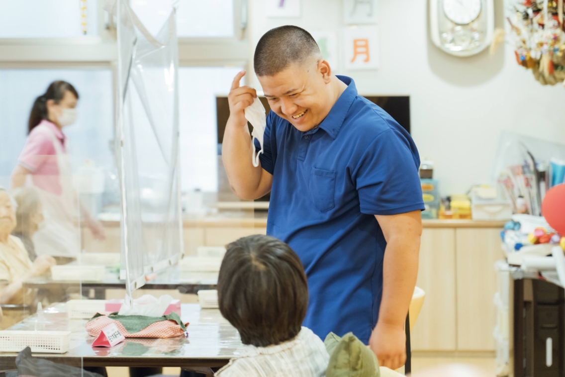 入所者と笑顔で会話する介護スタッフ