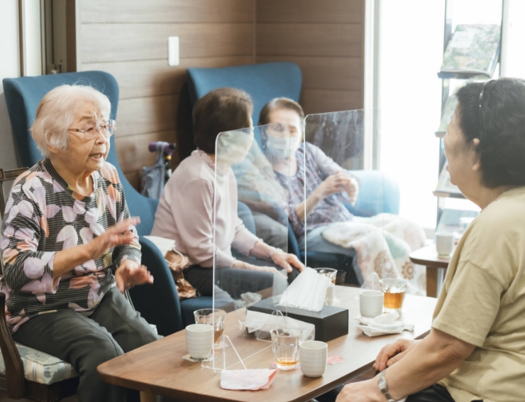 お昼ご飯を食べながら談笑する高齢者